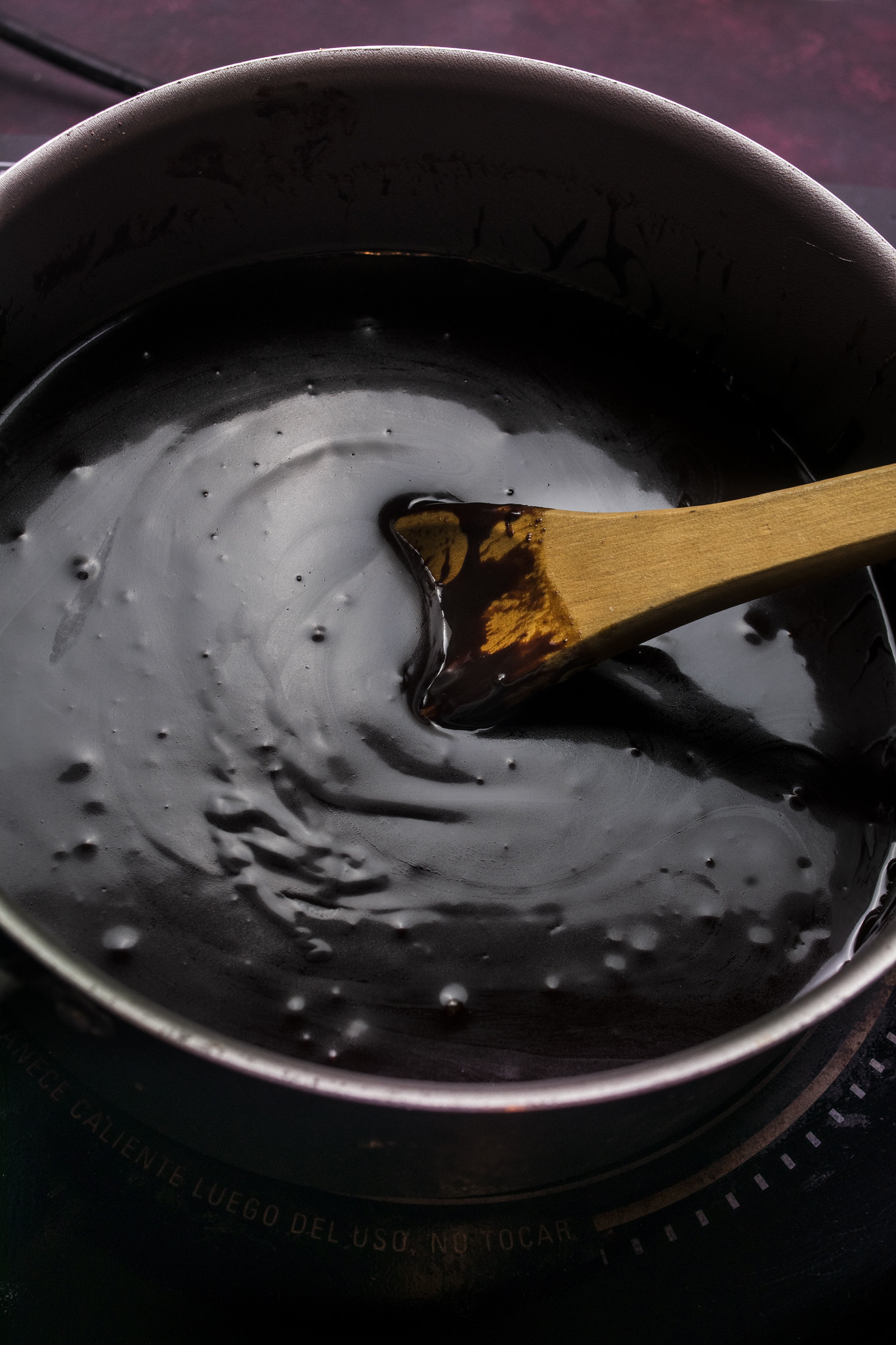 Glossy dark chocolate espresso ganache cooling in a saucepan.